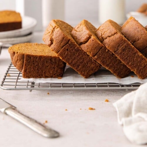 A side view of baked gluten-free pumpkin bread sliced on a wire rack