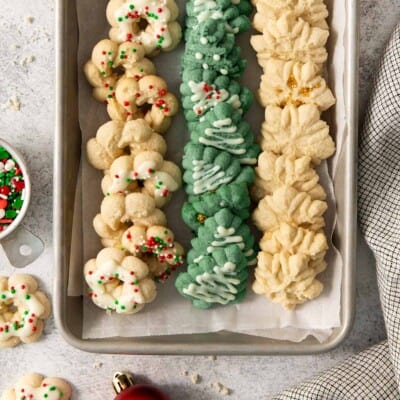 gluten-free spritz cookies lined up on a baking sheet