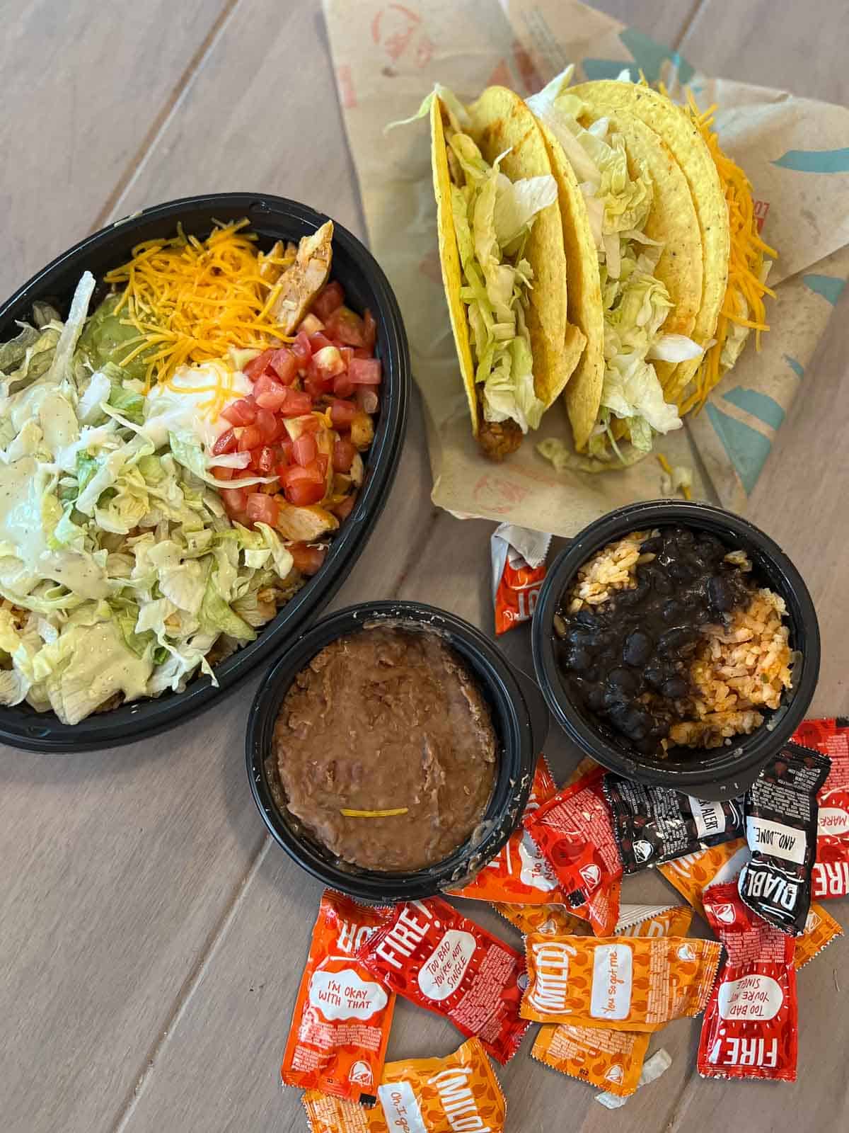 overhead shot of tacos, beans and taco bowl with hot sauce from taco bell