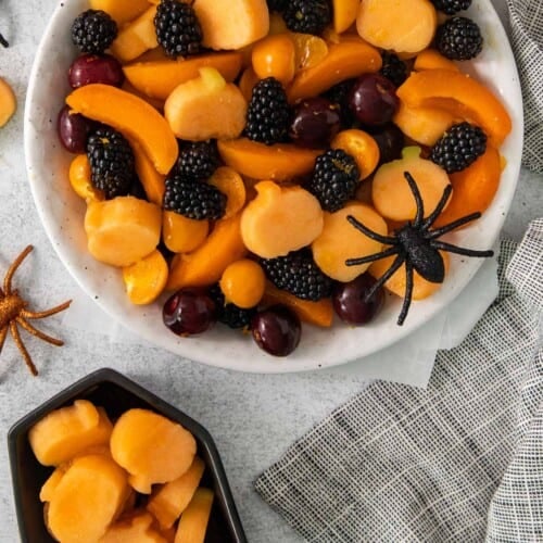 An overhead view of Halloween fruit salad in a bowl