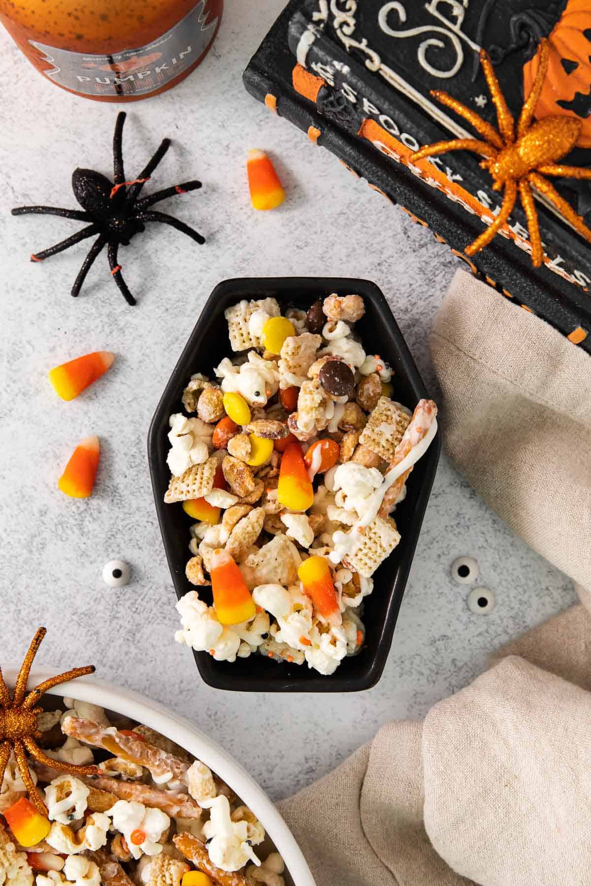 Halloween snack mix in a Halloween bowl with decorations around it