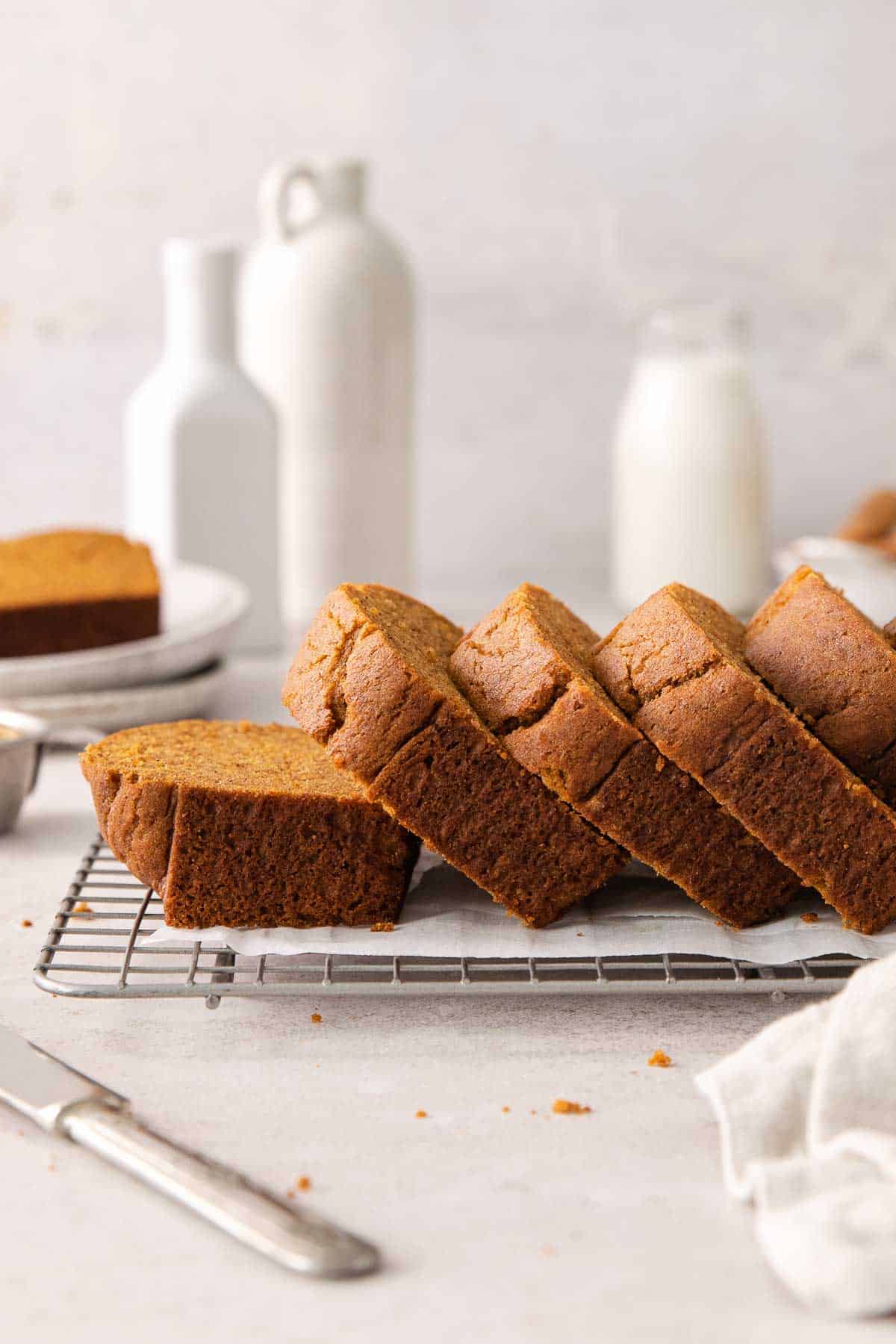 A side view of baked gluten-free pumpkin bread sliced on a wire rack