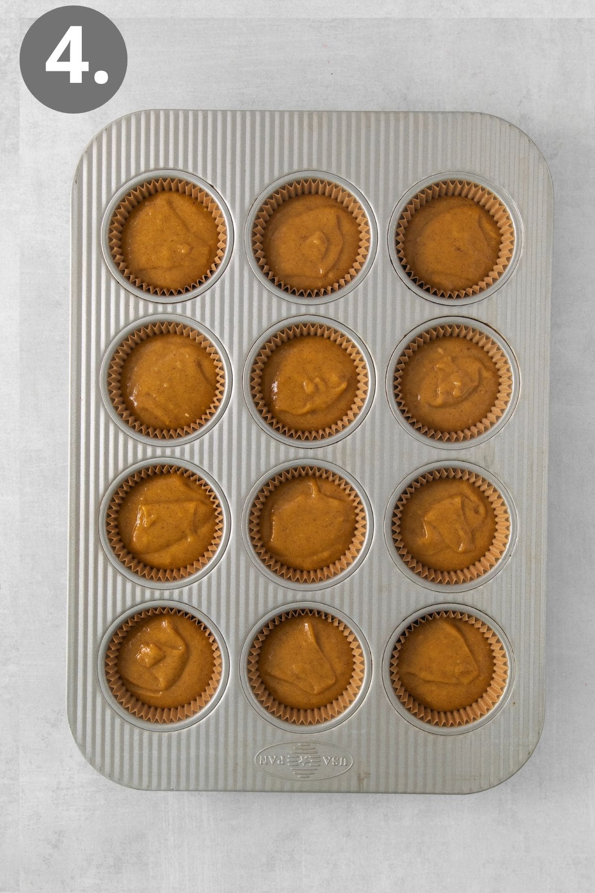 Gluten-free pumpkin cupcake batter in a muffin tin
