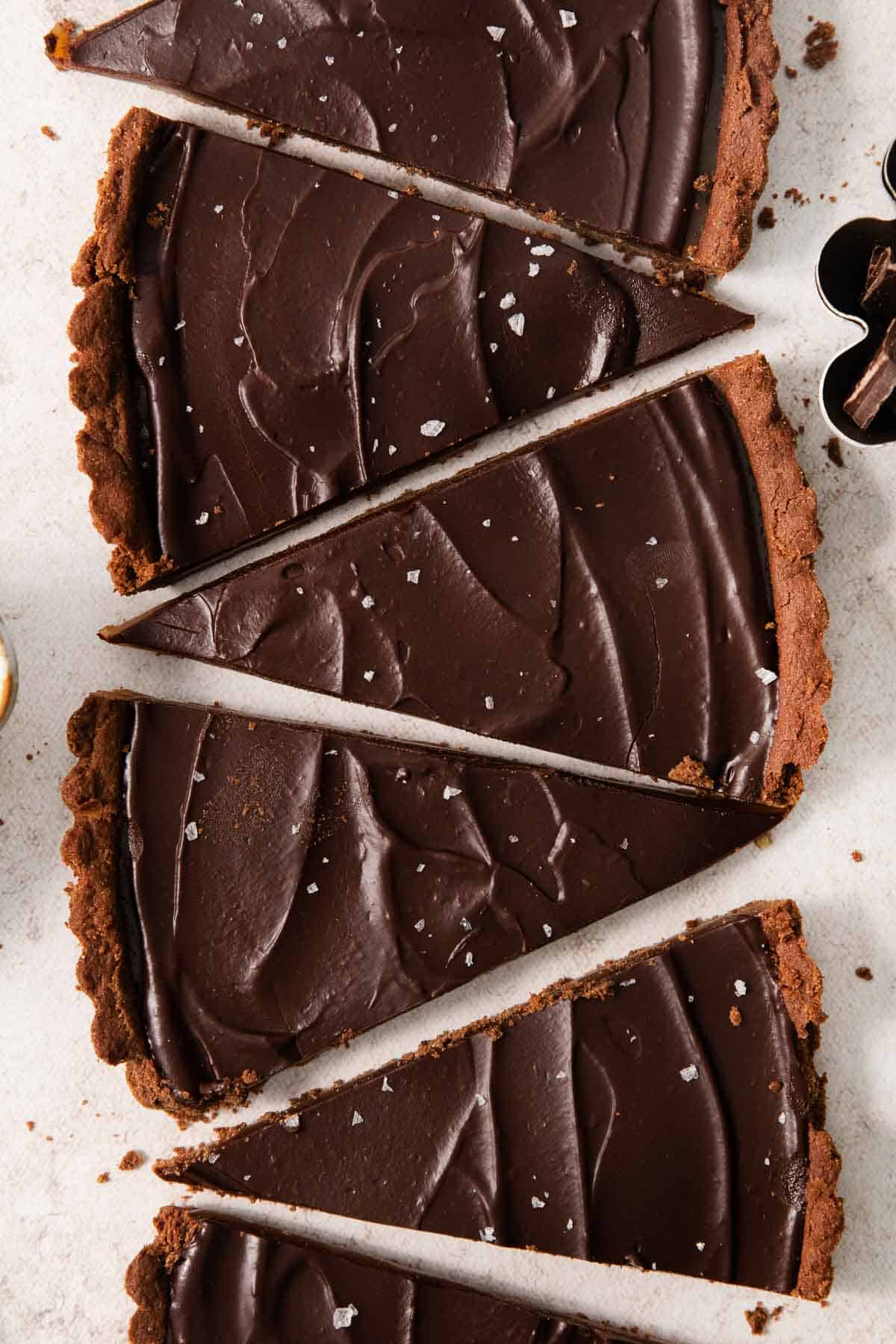 slices of gluten-free chocolate caramel tart lined up in a row on a countertop