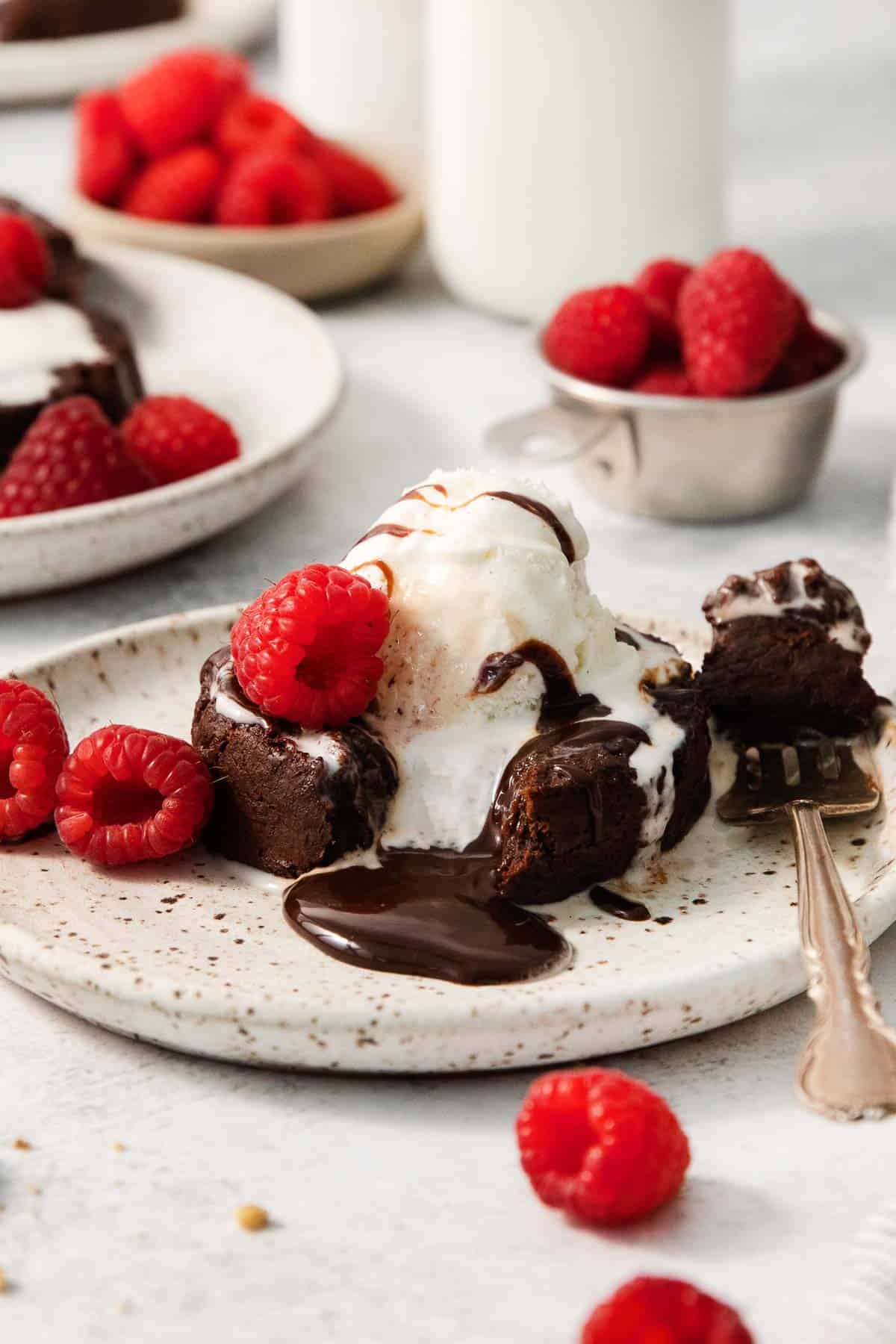 gluten-free chocolate lava cake on a plate with a fork taking a bite out of it