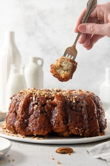 gluten-free monkey bread on a platter with a fork picking up a piece of monkey bread