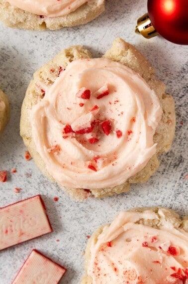 gluten-free peppermint cookies on a countertop with ornaments and white chocolate peppermint pieces around them