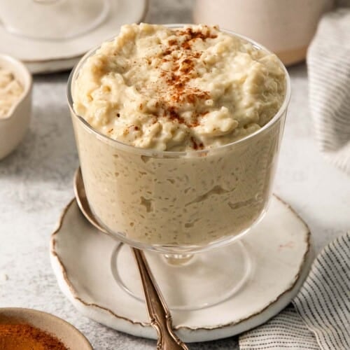 dairy-free rice pudding in a jar with a spoon resting beside it