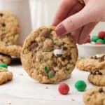a hand holding up one cadbury snowball cookie with more behind.