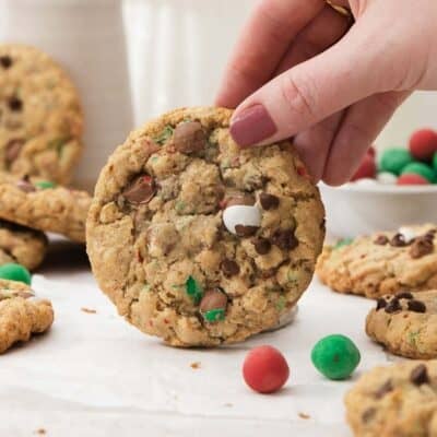 a hand holding up one cadbury snowball cookie with more behind.
