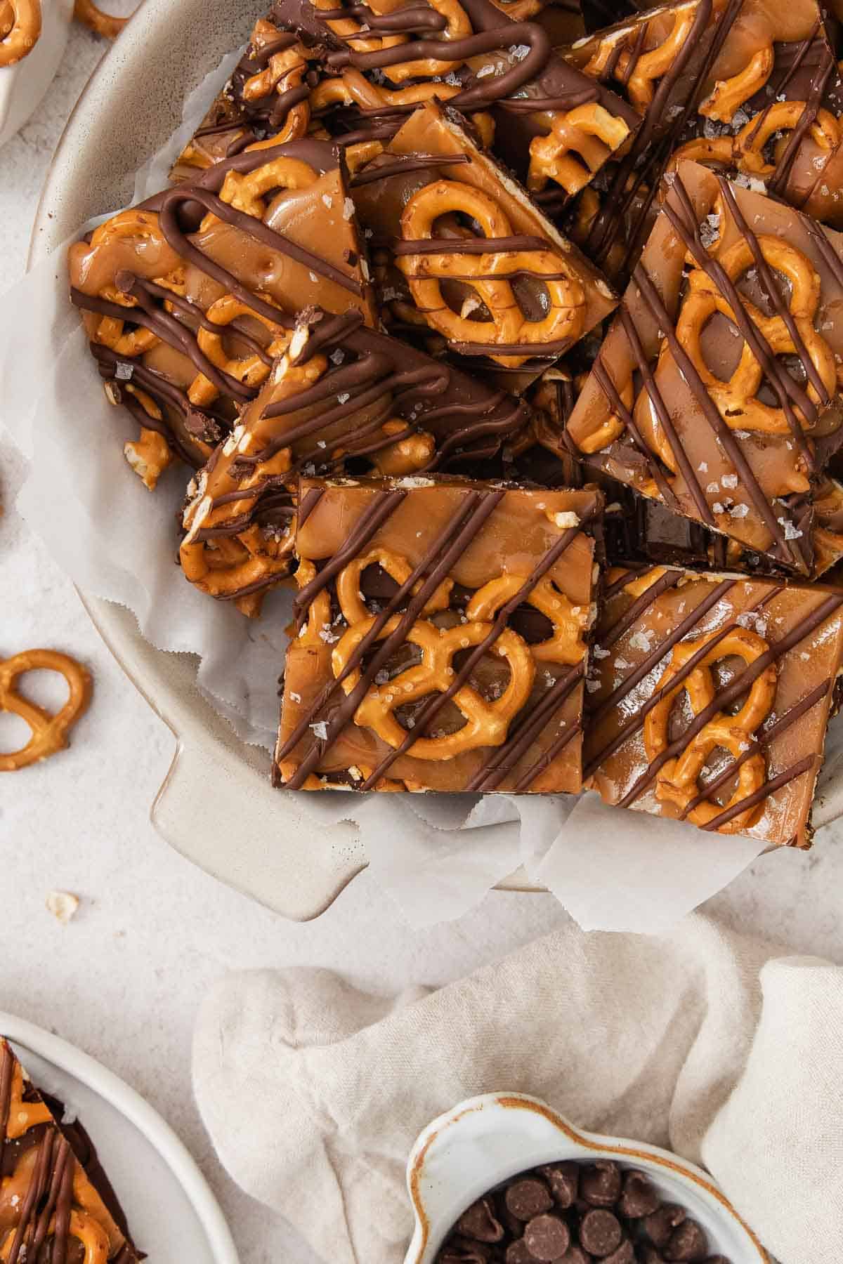 up-close of the salted caramel pretzel bark in a white dish with parchment paper.