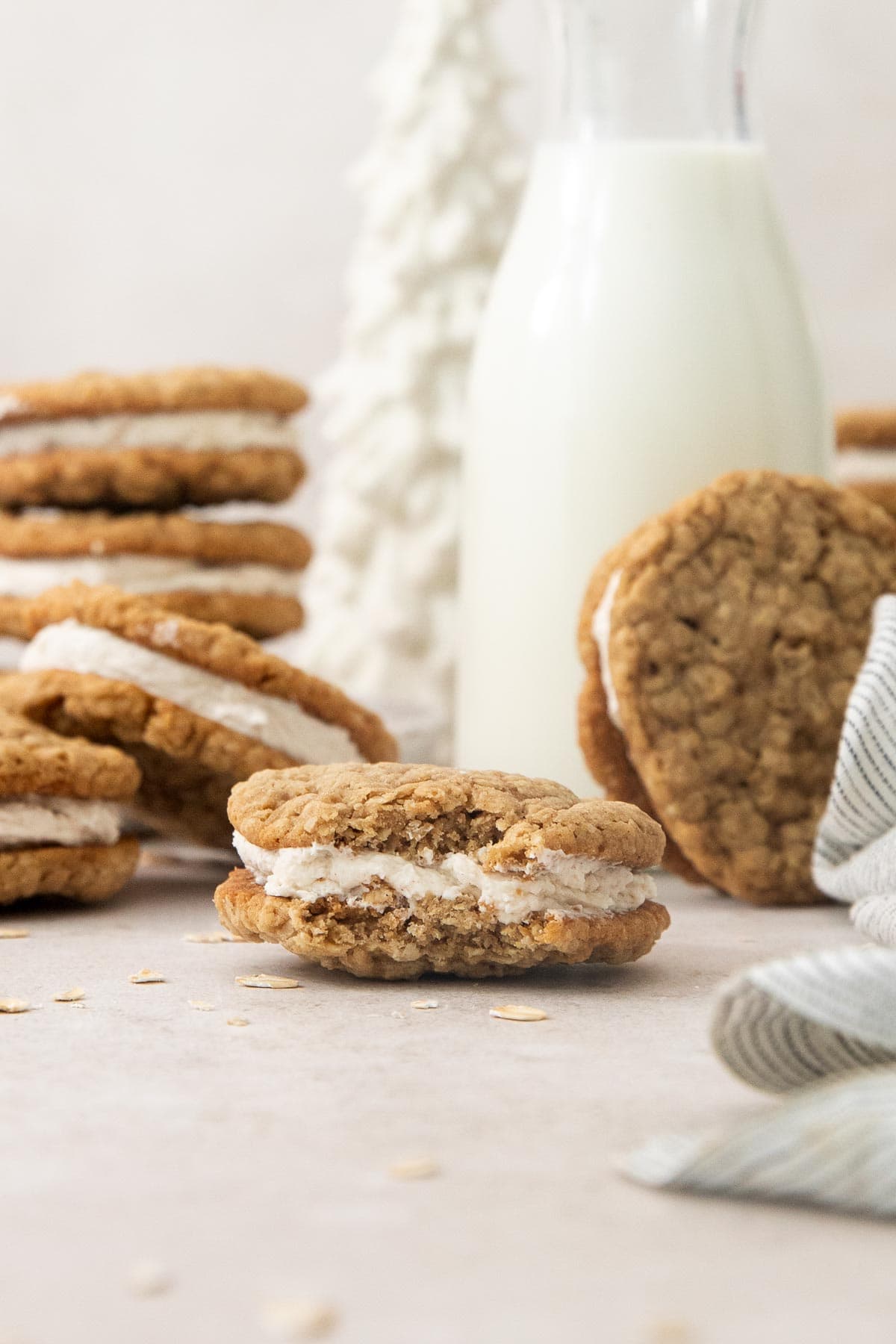 an eggnog oatmeal cream pie with a bite missing and more cookies behind.