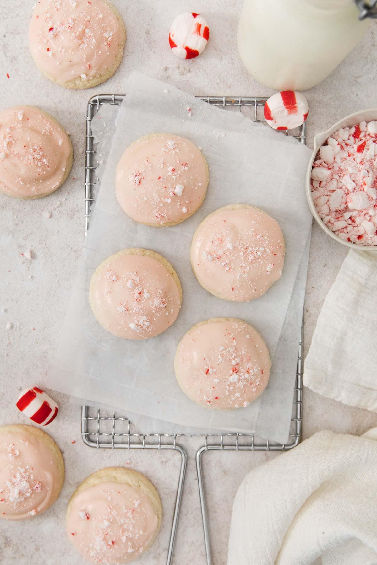 peppermint meltaways topped with glaze and crushed peppermint candies on a parchment lined wire rack.