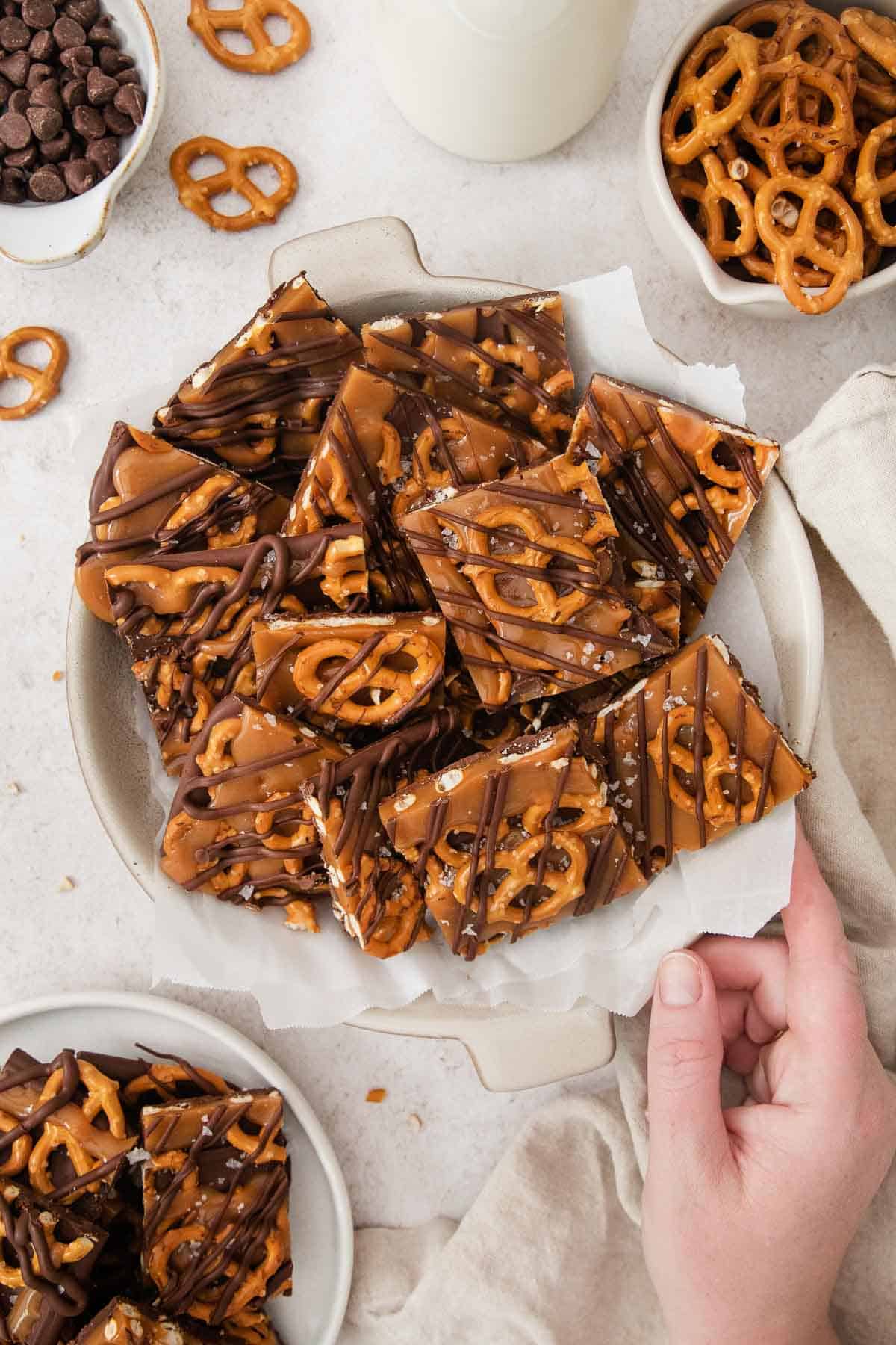 salted caramel pretzel bark in a white dish with parchment paper.