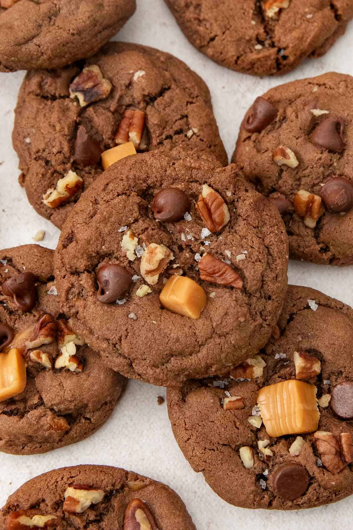 chocolate turtle cookies layers on a countertop.