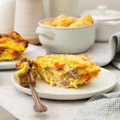 a slice of tater tot breakfast casserole with one bite on a fork.