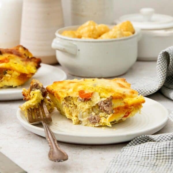 a slice of tater tot breakfast casserole with one bite on a fork.