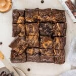 Gluten-free peanut butter brownies sliced on a piece of parchment.