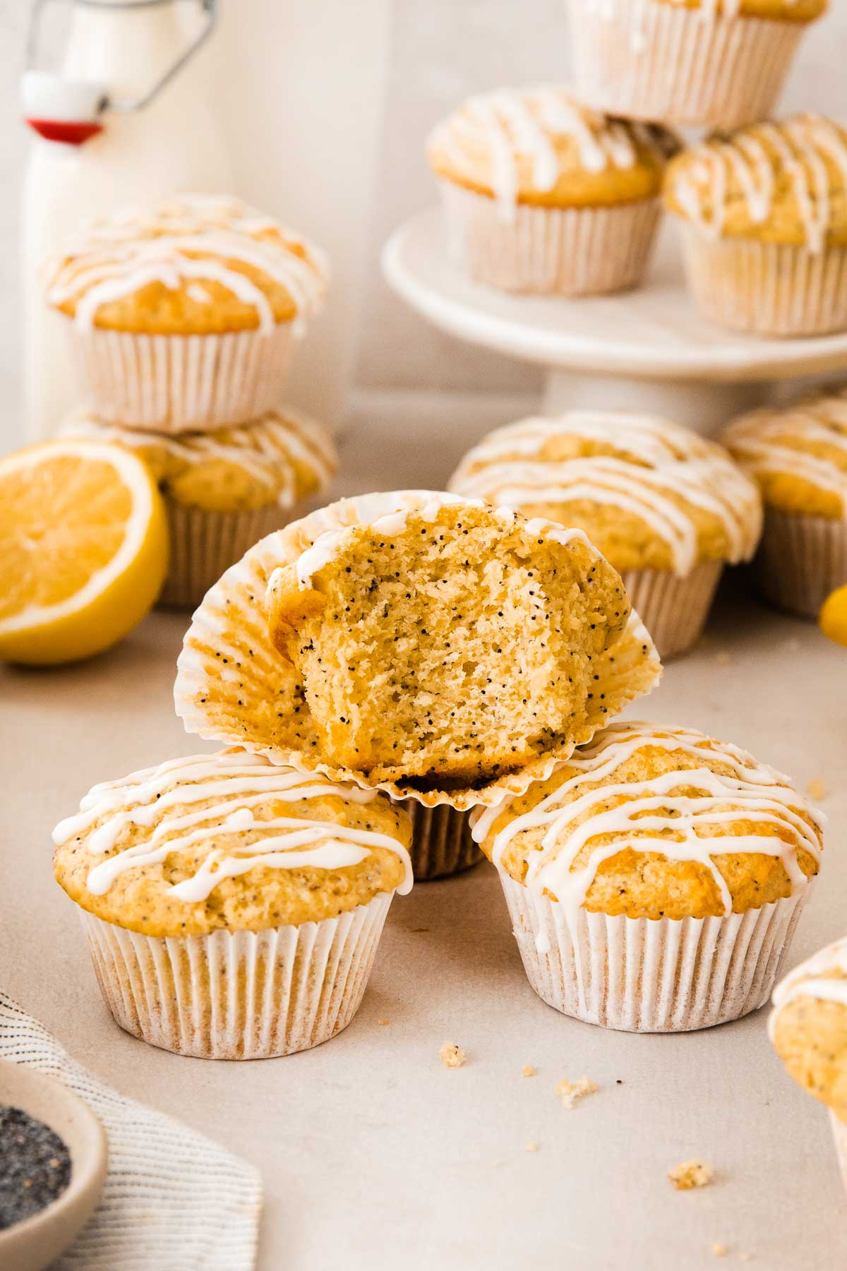 a lemon poppy seed muffin with one bite missing sitting on top of other muffins.