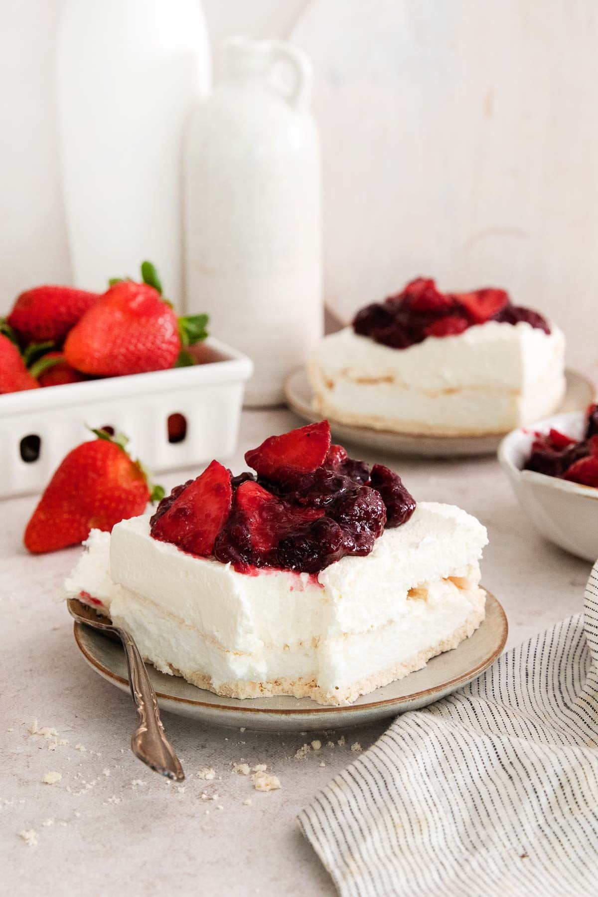 a serving of cherry berries on a cloud with one bite on a utensil.