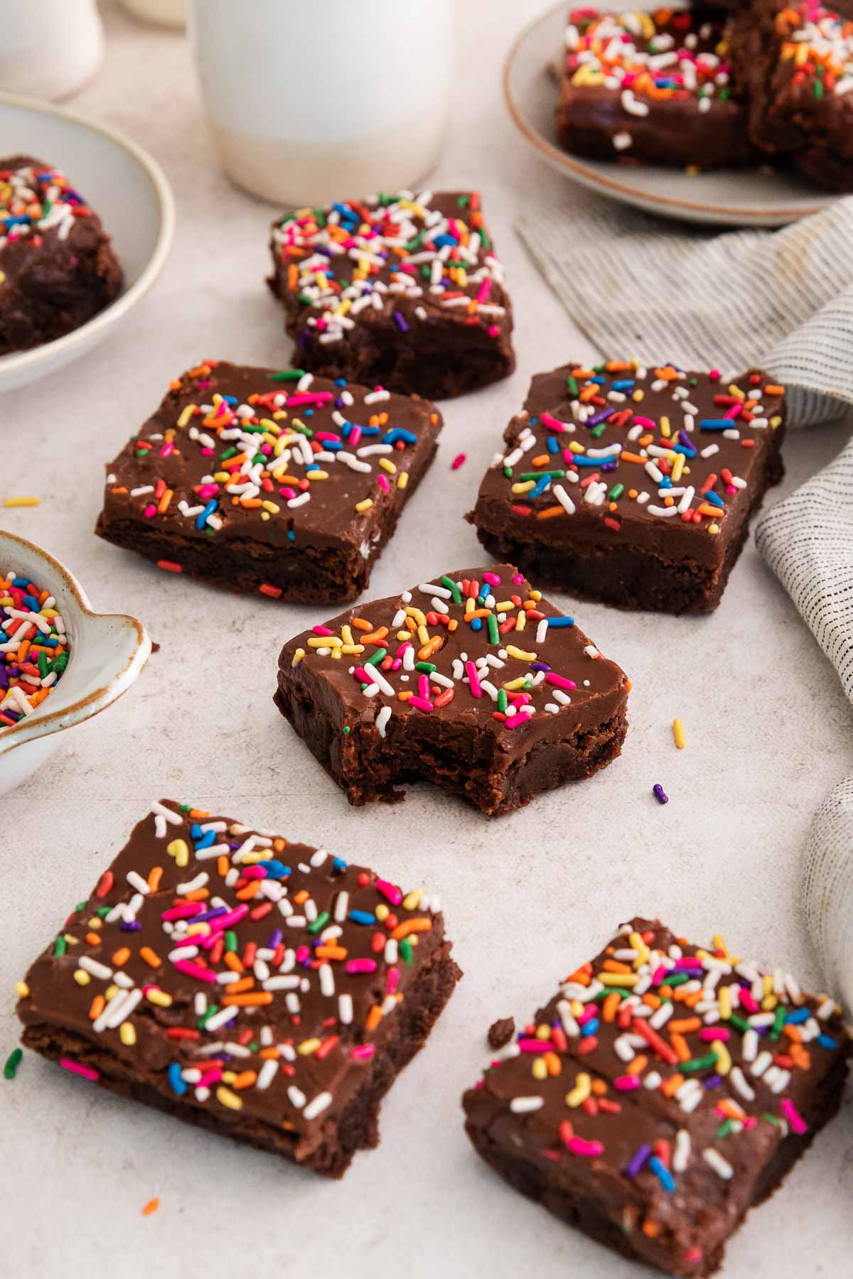 birthday brownies on a counter with a bite missing from one.