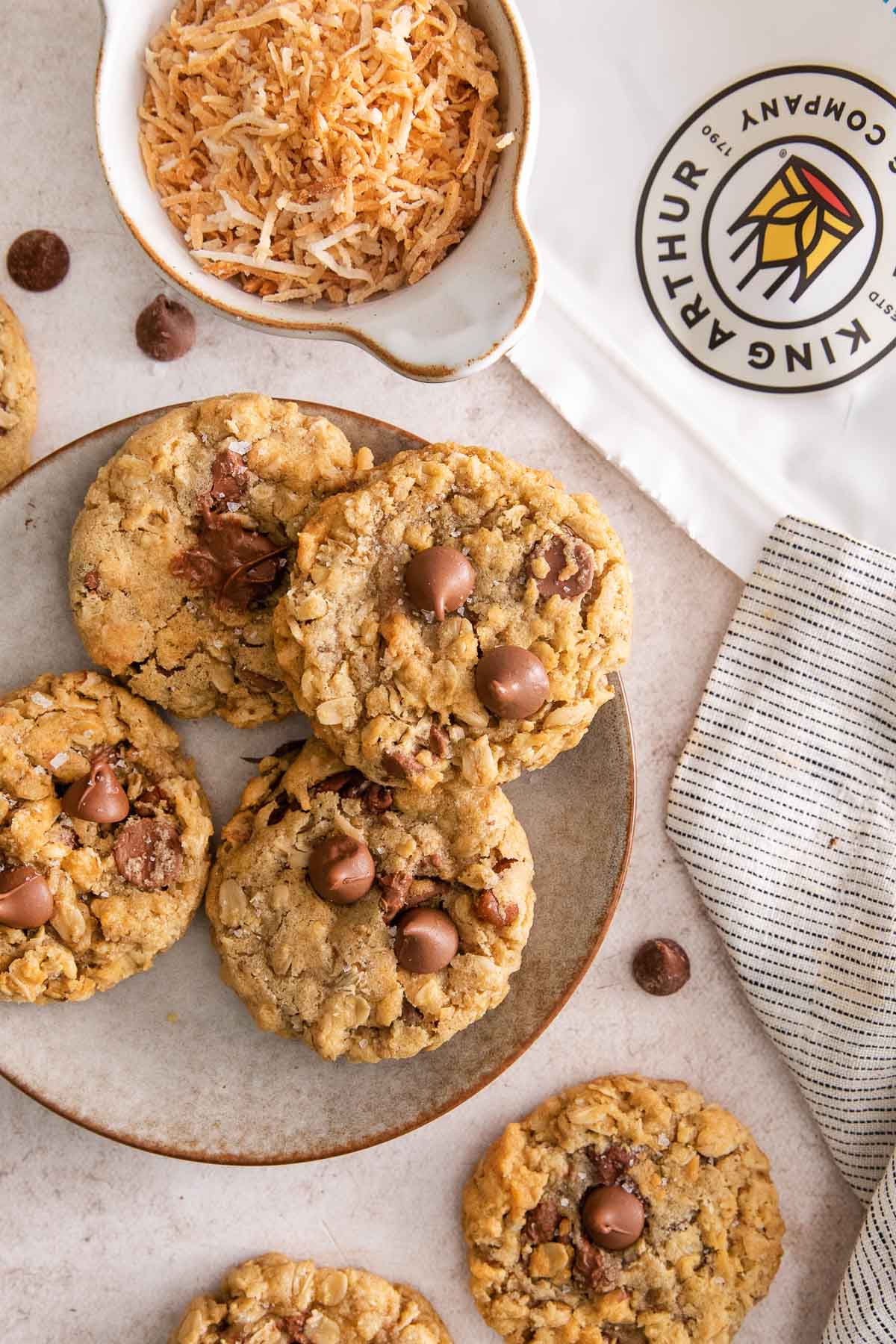 cowboy cookies on a plate with a bag of king arthur gluten-free flour nearby.