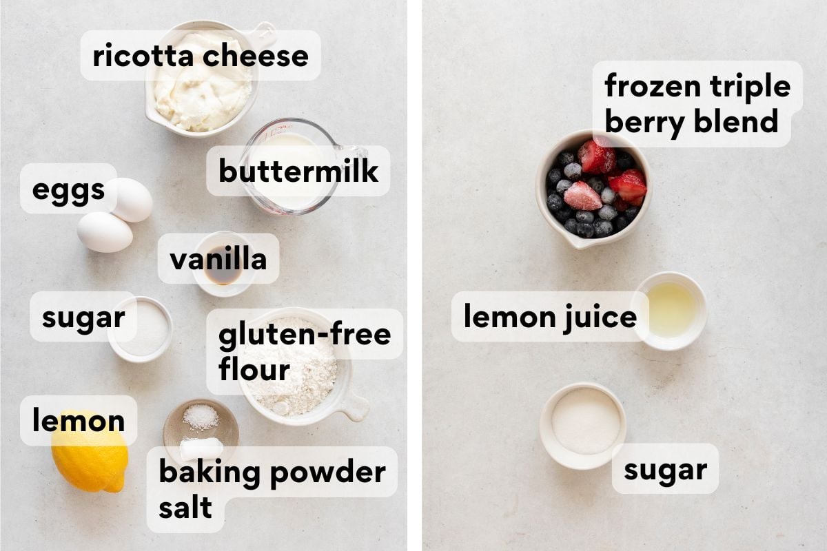 Top-down view of labeled baking ingredients including ricotta cheese, eggs, buttermilk, vanilla, sugar, lemon, gluten-free flour, baking powder, salt, frozen triple berry blend, and lemon juice on a light surface.